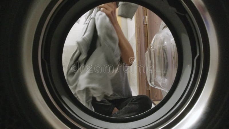 Vue statique belle femme heureuse mettre des vêtements à la machine à laver t banque de vidéos