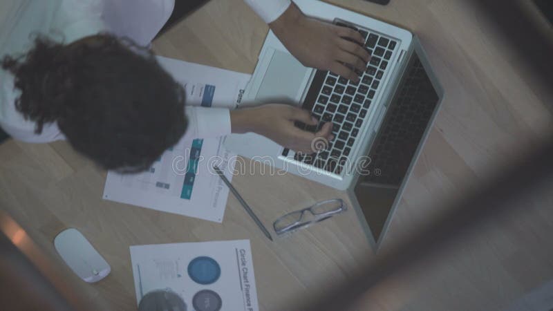 Vue supérieure de l'employé de bureau féminin dactylographiant sur l'ordinateur portable, jour ouvrable, réflexion dans le miroir banque de vidéos
