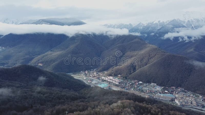 Vue supérieure de station de vacances près des montagnes avec les crêtes neigeuses Petite station de sports d'hiver au bas de la photo libre de droits Vue supérieure de station de vacances près des montagnes avec les crêtes neigeuses Petite station de sports d'hiver au bas de la photo libre de droits