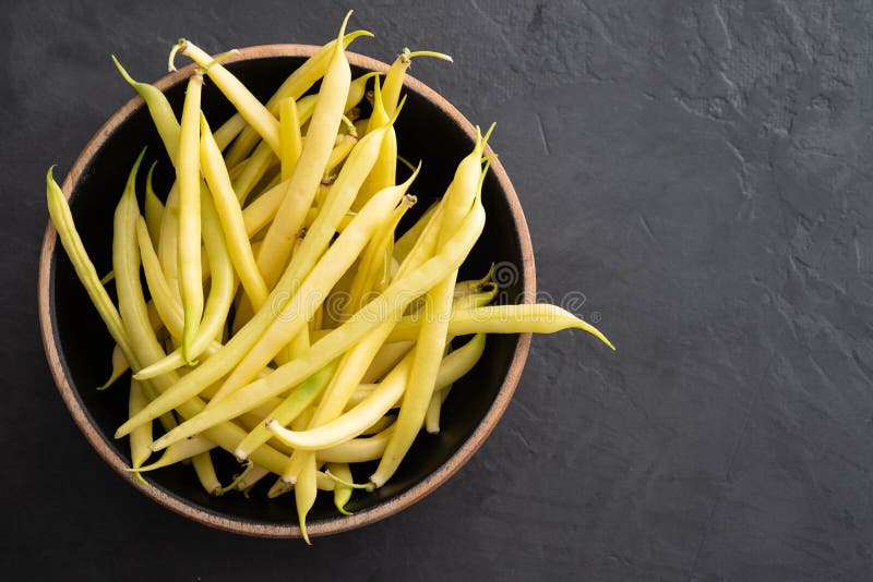 Vue supérieure haute étroite de haricots verts Haricots jaunes dans une cuvette noire photographie stock libre de droits Vue supérieure haute étroite de haricots verts Haricots jaunes dans une cuvette noire photographie stock libre de droits