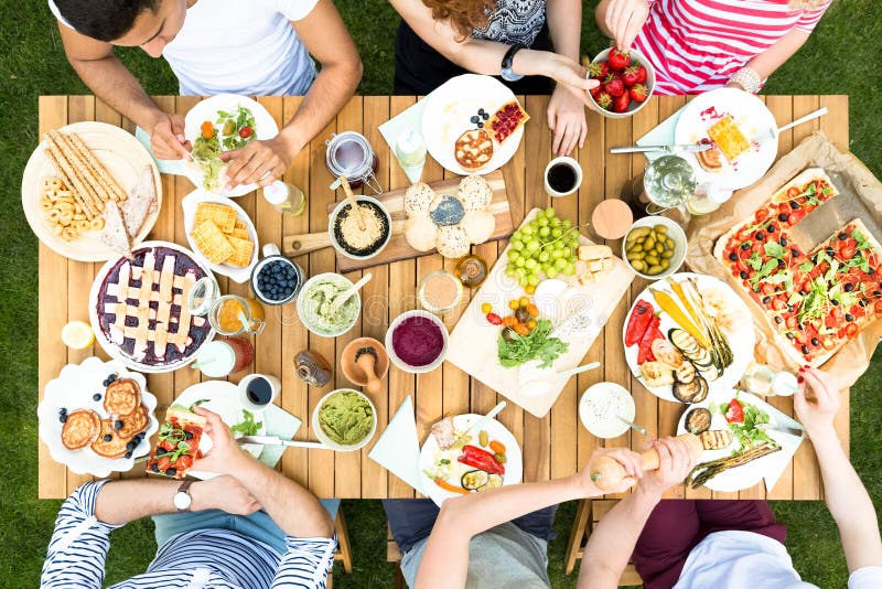 Vue supérieure sur le groupe multiculturel d'amis mangeant de la nourriture grillée d image stock