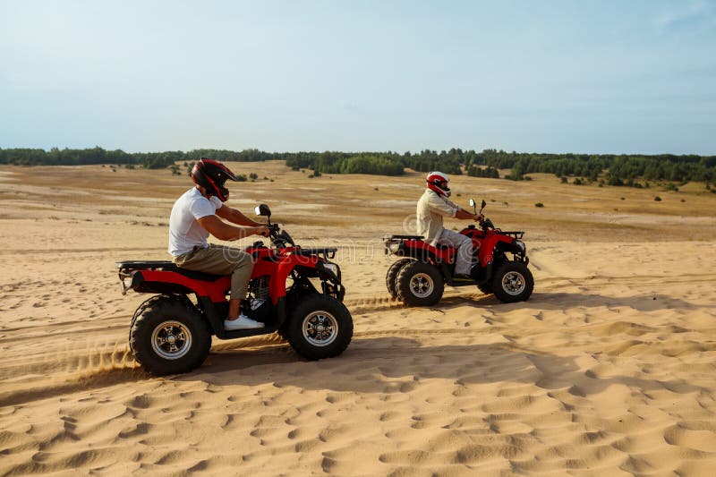 Des Hommes En Casques Et Lunettes Font Le Tour D'atv Dans Le Désert Image  stock - Image du rapide, piloter: 235577063