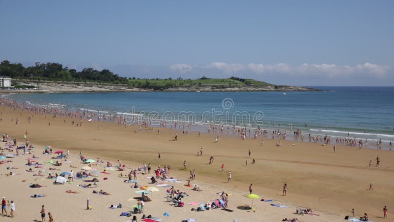 Vue sur la plage bondée pendant la chaude journée d'été dans la ville touristique populaire sur la rive de l'océan atlantique banque de vidéos