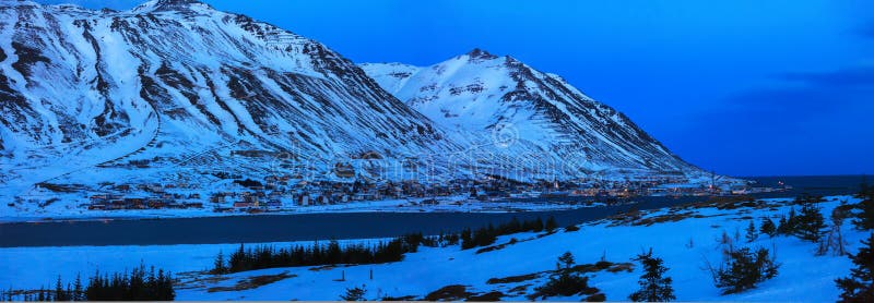 Vue sur Siglufjordur au crépuscule en hiver, Islande Siglufjordur est situé dans le beau fjord du même nom, et haute et DR photos libres de droits Vue sur Siglufjordur au crépuscule en hiver, Islande Siglufjordur est situé dans le beau fjord du même nom, et haute et DR photos libres de droits