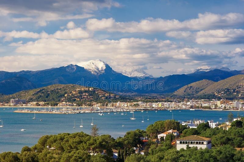 View to Port de Pollenca, snowy mountains from the Tramuntana mountain in the background. View to Port de Pollenca, snowy mountains from the Tramuntana mountain in the background