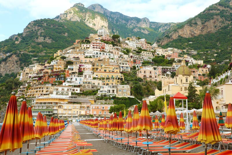 Vue étonnante de ville de Positano de la plage avec des parapluies et des chaises de plate-forme, côte d'Amalfi, Italie images stock Vue étonnante de ville de Positano de la plage avec des parapluies et des chaises de plate-forme, côte d'Amalfi, Italie images stock