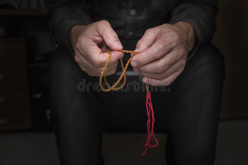 Vue étroite du men& x27 ; mains de s avec le chapelet photos stock Vue étroite du men& x27 ; mains de s avec le chapelet photos stock