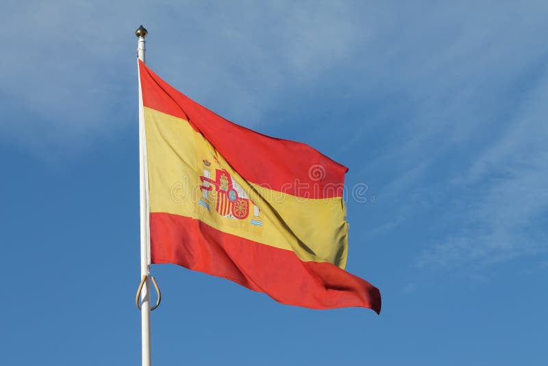 Vuelo español de la bandera contra el cielo azul marino fotografía de archivo libre de regalías Vuelo español de la bandera contra el cielo azul marino fotografía de archivo libre de regalías