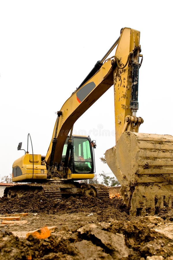 Yellow and black dirty excavator parked on the construction site. Yellow and black dirty excavator parked on the construction site.