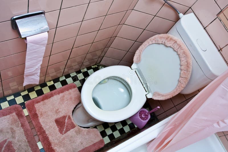 Dirty old toilet with pink ceramic tiles. Dirty old toilet with pink ceramic tiles