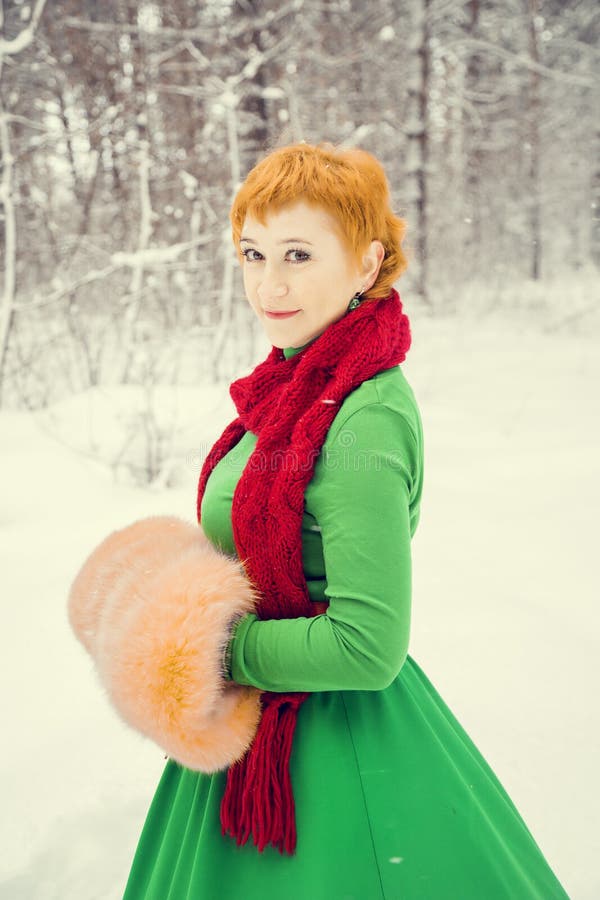 Vurige roodharige vrouw in een bal groene kleding met een rode leerriem in het kostuum van dwerg hulpsanta claus in de winter F stock foto's Vurige roodharige vrouw in een bal groene kleding met een rode leerriem in het kostuum van dwerg hulpsanta claus in de winter F stock foto's