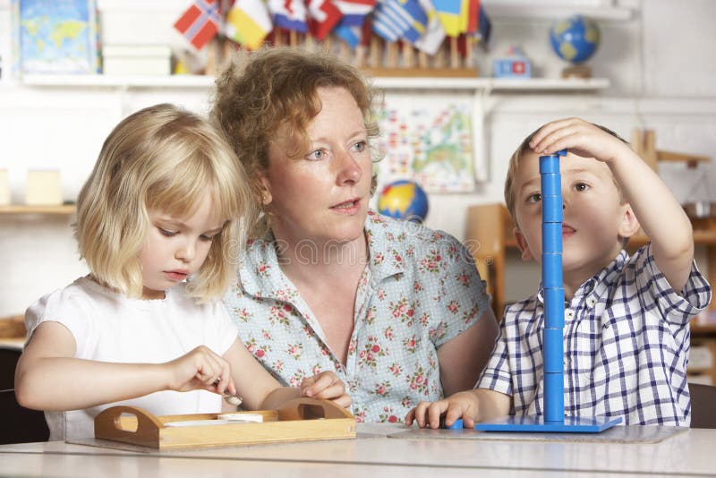 vuxna barn som hjälper montessori pre två barn royaltyfria bilder vuxna barn som hjälper montessori pre två barn royaltyfria bilder