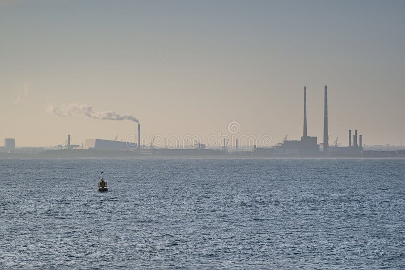 Beautiful hazy evening view of Dublin Waste to Energy Covanta Plant, Poolbeg CCGT and Pigeon House Power Station view from Dun Laoghaire harbor, Dublin, Ireland. Soft and selective focus. Beautiful hazy evening view of Dublin Waste to Energy Covanta Plant, Poolbeg CCGT and Pigeon House Power Station view from Dun Laoghaire harbor, Dublin, Ireland. Soft and selective focus