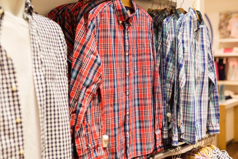 Várias camisas na loja da roupa dos homens no shopping para a venda fotografia de stock royalty free Várias camisas na loja da roupa dos homens no shopping para a venda fotografia de stock royalty free