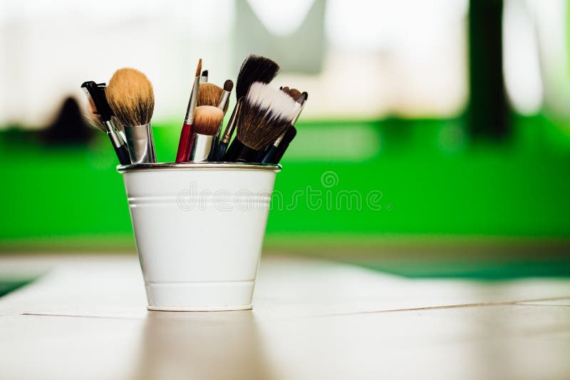 Vários escovas e lápis da composição na luz - fundo verde dentro da cubeta o assoalho Copyspace imagem de stock Vários escovas e lápis da composição na luz - fundo verde dentro da cubeta o assoalho Copyspace imagem de stock