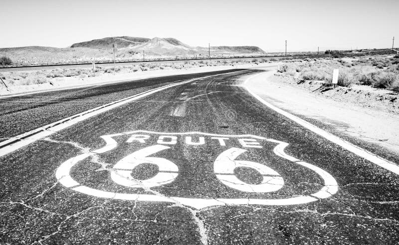 Route 66 cracked sign on hot asphalt in black and white in the desert. Route 66 cracked sign on hot asphalt in black and white in the desert.