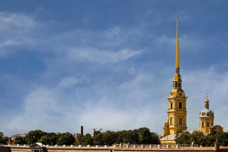 Magnificent view of the buildings of the Peter and Paul Fortress in the center of St. Petersburg, Russia, towers of an ancient Orthodox cathedral with a huge gilded spire, domes and crosses, sky and clouds, European architecture, green plants, cityscape, summer. Magnificent view of the buildings of the Peter and Paul Fortress in the center of St. Petersburg, Russia, towers of an ancient Orthodox cathedral with a huge gilded spire, domes and crosses, sky and clouds, European architecture, green plants, cityscape, summer.