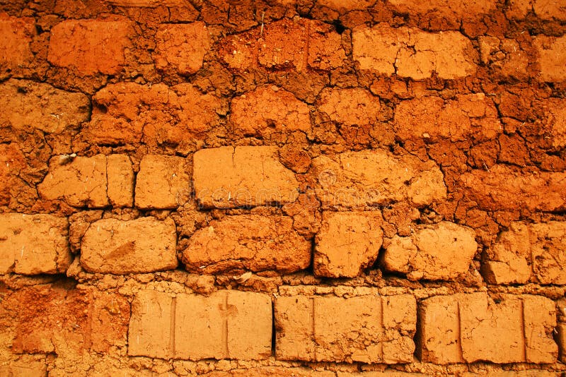 Wall of a house in red clay, earth or soil bricks, great texture background, poverty, developing or tropical country concept. Wall of a house in red clay, earth or soil bricks, great texture background, poverty, developing or tropical country concept.