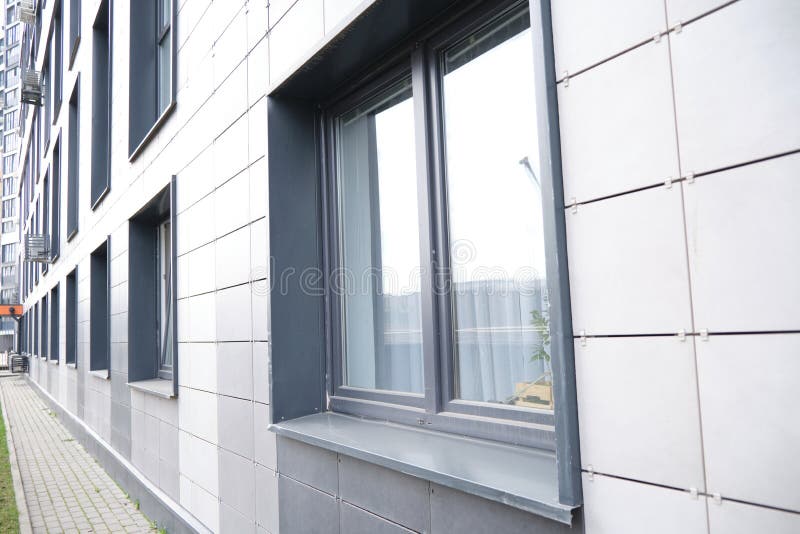 Väggbeklädnad av metallplattor med fönster. Uppgifter om moderna bostadshus på keramik arkivfoton