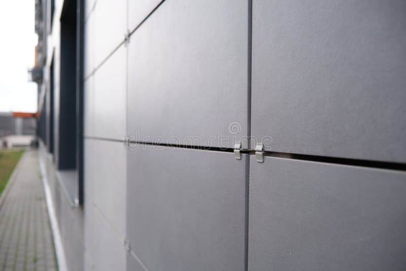 Väggbeklädnad av metallplattor med fönster. Uppgifter om moderna bostadshus på keramik royaltyfria foton