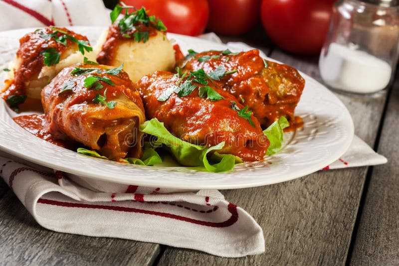 Välfylld kål med kött och ris tjänade som med kokta potatisar och tomatsås royaltyfri foto Välfylld kål med kött och ris tjänade som med kokta potatisar och tomatsås royaltyfri foto