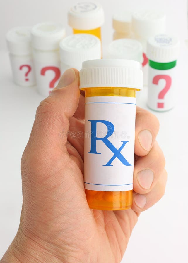 A hand holding a medicine bottle marked with an Rx pharmacy mark. A variety of pill bottles labeled with large question marks are in the background. A hand holding a medicine bottle marked with an Rx pharmacy mark. A variety of pill bottles labeled with large question marks are in the background.