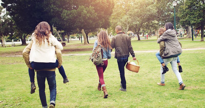 Vänner tillbaka och promenera i parken för picknickbindning och slappna av på helgen med korg på sommaren. grupp av människor roli royaltyfri foto