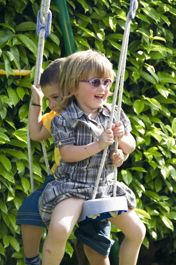 Friends playing on the playground swing. Friends playing on the playground swing