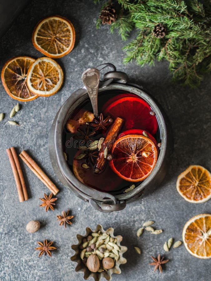 Värmealkoholdryck för traditionell vinter - funderat vin Varmt vin med frukter och kryddor i tappningmetallkastare på mörkt - grå arkivfoto Värmealkoholdryck för traditionell vinter - funderat vin Varmt vin med frukter och kryddor i tappningmetallkastare på mörkt - grå arkivfoto