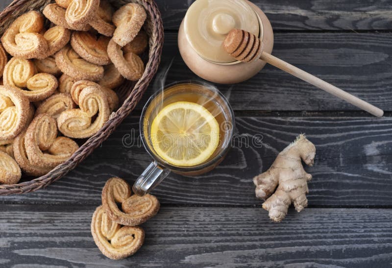 Värmedryck med citronhonung och ingefärg med kakor för gingerbröd på träbakgrund royaltyfri foto