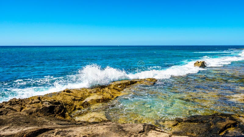 Vågor av Stilla havet som kraschar på den steniga shorelinen av västkusten av ön av Oahu arkivfoton