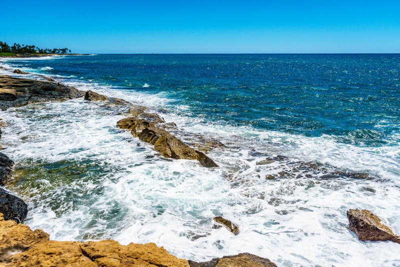 Vågor av Stilla havet som kraschar på den steniga shorelinen av västkusten av ön av Oahu arkivbilder