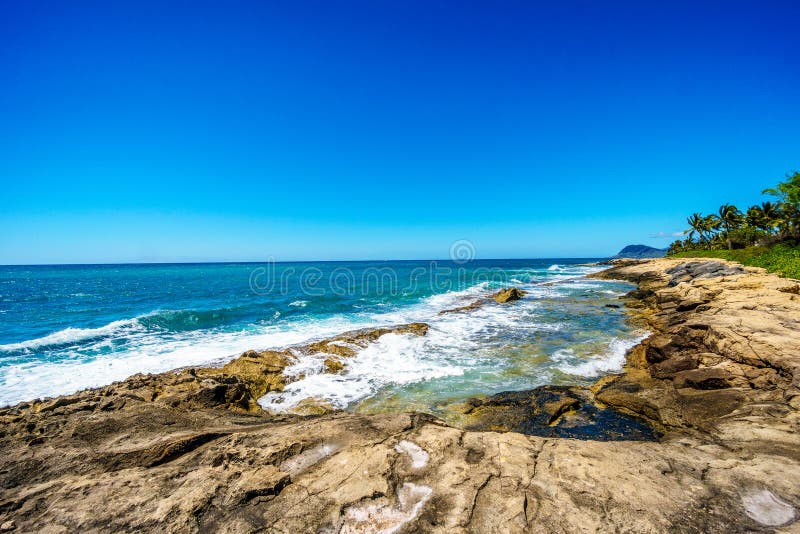 Vågor av Stilla havet som kraschar på den steniga shorelinen av västkusten av ön av Oahu royaltyfria bilder