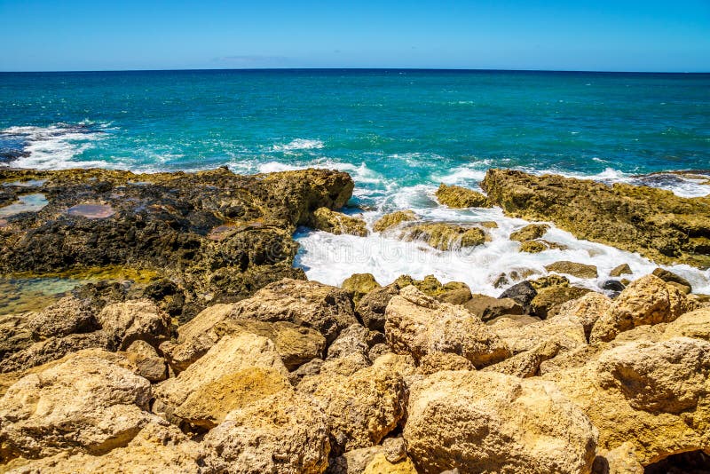 Vågor av Stilla havet som kraschar på den steniga shorelinen av västkusten av ön av Oahu arkivfoton