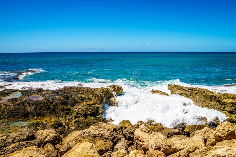 Vågor av Stilla havet som kraschar på den steniga shorelinen av västkusten av ön av Oahu royaltyfri foto