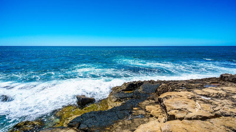 Vågor av Stilla havet som kraschar på den steniga shorelinen av västkusten av ön av Oahu fotografering för bildbyråer