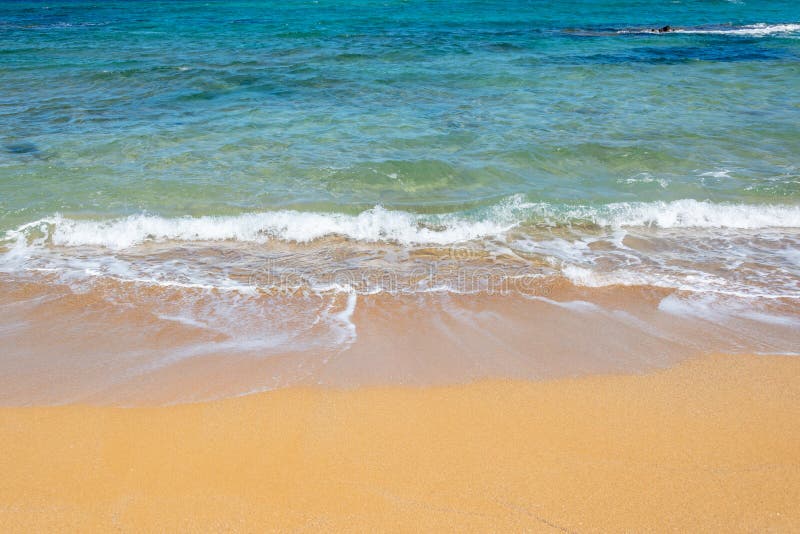 V?gor p? en strand med orange sand royaltyfri bild V?gor p? en strand med orange sand royaltyfri bild