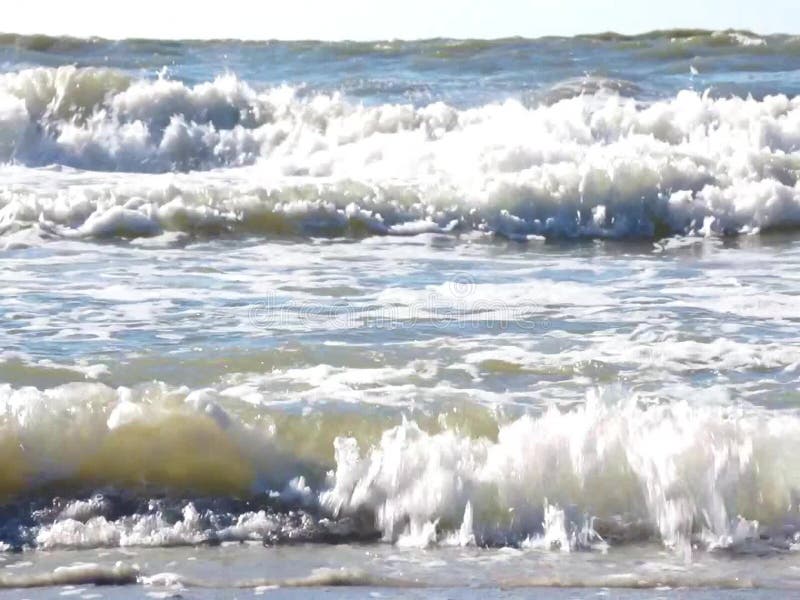 Vågor som kraschar på en sandig strand