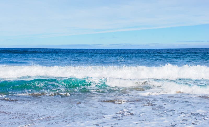 Vågor som rullar in mot stranden, gör perfekt blått- och aquahavvatten, altostratusmoln i himlen arkivbild Vågor som rullar in mot stranden, gör perfekt blått- och aquahavvatten, altostratusmoln i himlen arkivbild