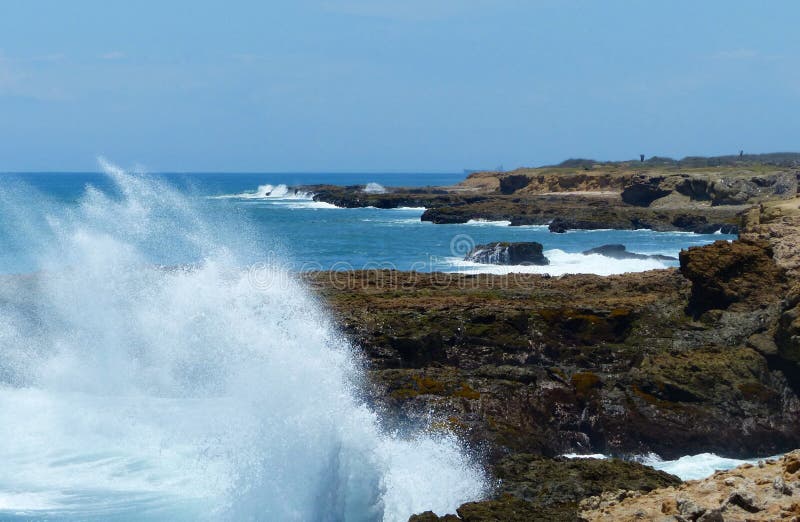 Vågorna från det fredliga havet som kraschar mot berget royaltyfria bilder