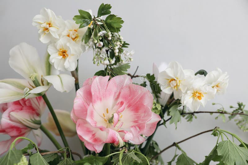 Vårbrobukett av blandade trädgårdsblommor på vintagets grå vägg baksida bakom. tilltäppning av rosa tulpandiller arkivfoton