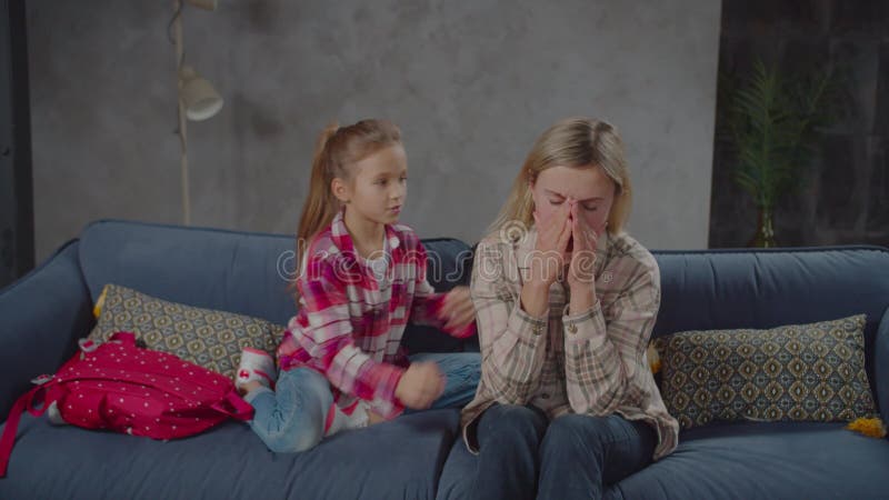 Vårdande liten flicka som tröttnar på orolig mamma hemma arkivfilmer