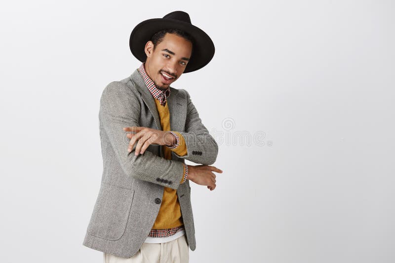 Vérifiez mon nouvel équipement Portrait d'étudiant masculin à la peau foncée sûr élégant dans le chapeau à la mode, faisant des g photo libre de droits Vérifiez mon nouvel équipement Portrait d'étudiant masculin à la peau foncée sûr élégant dans le chapeau à la mode, faisant des g photo libre de droits