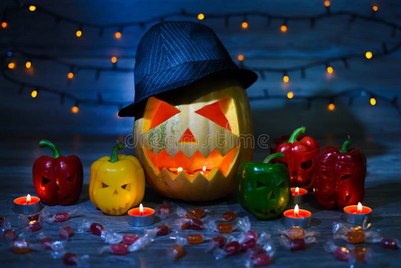 Véspera do ` s de Dia das Bruxas a Jack-o-lanterna em um chapéu e em velas para dentro, scaring a cara ilumina grightening azul i fotos de stock Véspera do ` s de Dia das Bruxas a Jack-o-lanterna em um chapéu e em velas para dentro, scaring a cara ilumina grightening azul i fotos de stock