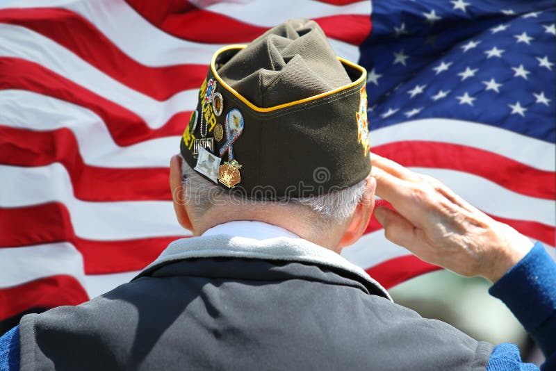 Vétéran saluant devant le drapeau des USA
