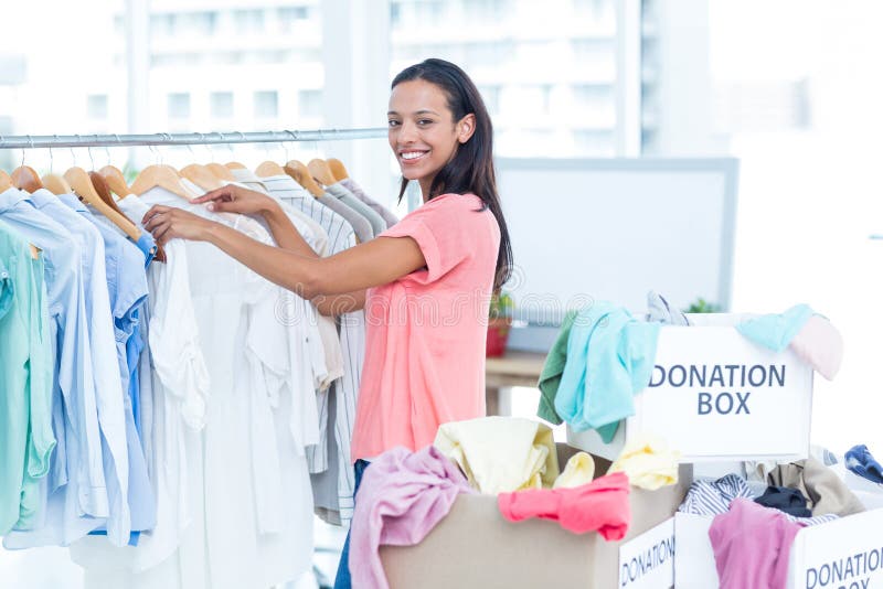 Vêtements de séparation volontaires de sourire de jeune femelle images stock Vêtements de séparation volontaires de sourire de jeune femelle images stock