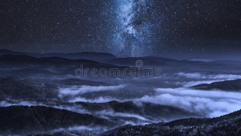 Vía láctea sobre las nubes que fluyen en las montañas de Tatra, Polonia