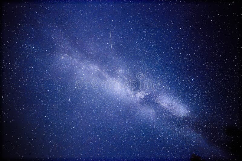 Vía láctea y un satélite Esta fotografía astronómica de la exposición larga del Cygnus de la nebulosa se admite el centro de la n fotografía de archivo Vía láctea y un satélite Esta fotografía astronómica de la exposición larga del Cygnus de la nebulosa se admite el centro de la n fotografía de archivo