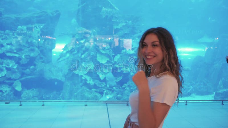 Vídeo de estilo de vida Feliz joven mujer disfrutar del acuario marino. Gesto de la turista femenina que muestra la mano de la ola almacen de video