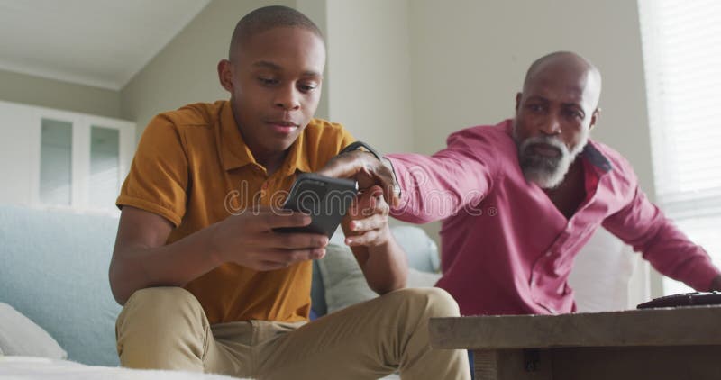 Vídeo do pai americano africano nervoso levando seu filho para o smartphone e gritando